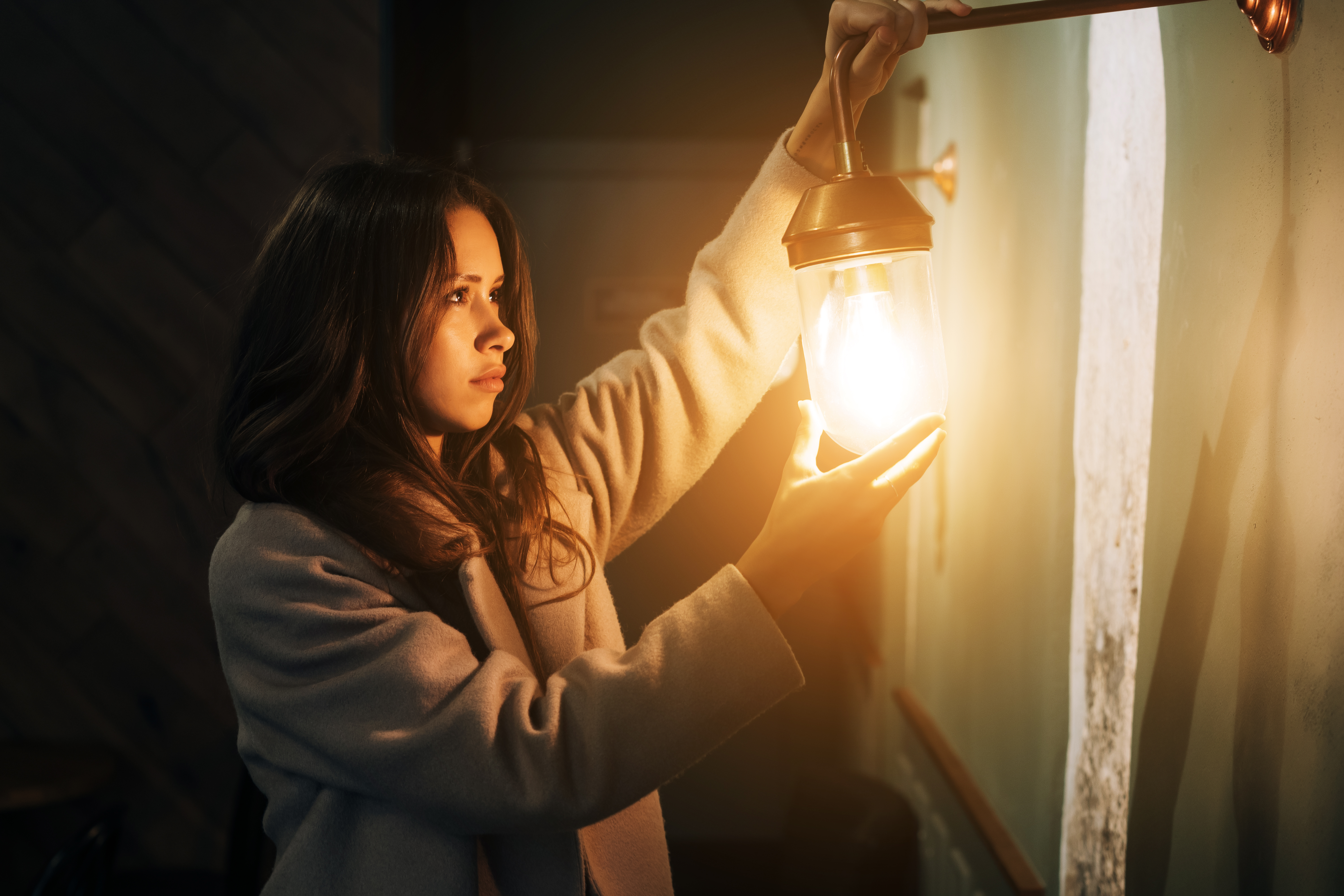 Donna con lampada da parete accesa